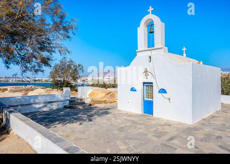 Piccola cappella greca bianca sulla scogliera sul mare presso la spiaggia di Agia Anna, l'isola di Naxos, le Cicladi, Grecia Foto Stock