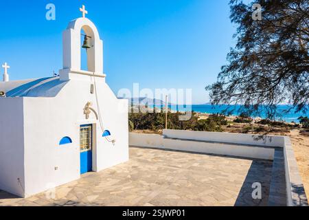 Piccola cappella greca bianca sulla scogliera sul mare presso la spiaggia di Agia Anna, l'isola di Naxos, le Cicladi, Grecia Foto Stock