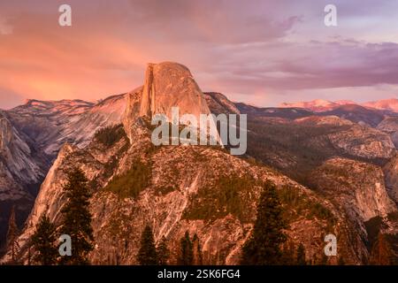 Tramonto sulle iconiche vedute del Yosemite Valley Floor, dell'Half Dome e delle alte montagne della Sierra dal Glacier Point Trailhead al Parco Nazionale di Yosemite Foto Stock