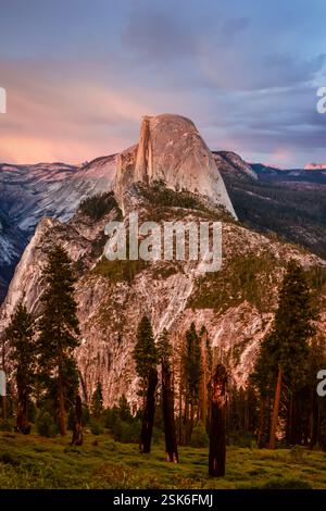 Tramonto sulle iconiche vedute del Yosemite Valley Floor, dell'Half Dome e delle alte montagne della Sierra dal Glacier Point Trailhead al Parco Nazionale di Yosemite Foto Stock