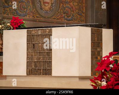 Cremona, Italia - 9 febbraio 2025 altare in marmo bianco con decorazioni in bronzo e poinsettias durante il periodo natalizio nella cattedrale di Santa Maria Assunta C. Foto Stock