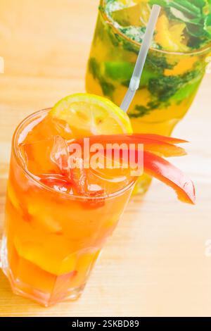 Rinfrescanti bevande estive con agrumi ed erbe aromatiche servite su un tavolo di legno Foto Stock