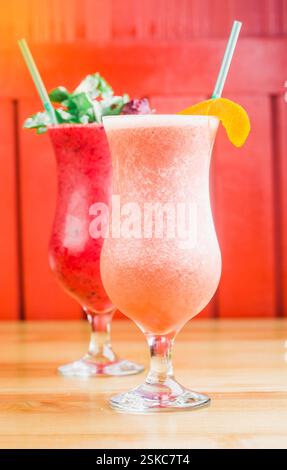 Rinfrescanti cocktail estivi serviti in bicchieri eleganti in un vivace ambiente bar durante il pomeriggio soleggiato Foto Stock