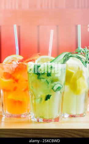 Bevande rinfrescanti colorate servite in bicchieri con decorazioni durante un pomeriggio di sole Foto Stock