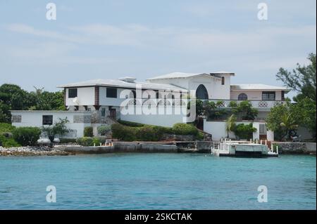 Grande villa bianca con balconi che si affacciano sull'oceano turchese. Paesaggio tropicale e molo privato su Paradise Island, Bahamas. Un simbolo di lusso Foto Stock