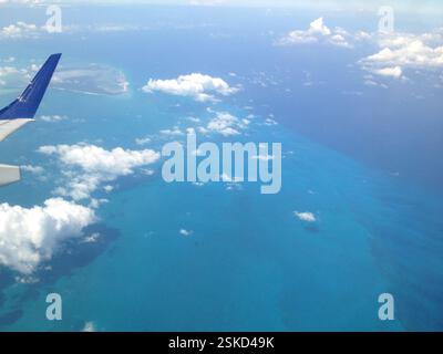 Foto aerea di acque turchesi poco profonde con macchie verdi scure. L'acqua bassa rivela forme vorticose delle barriere coralline. Le barriere coralline sono biodiversità Foto Stock