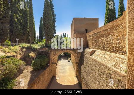 Acquedotto dell'Acequia Real nel complesso dell'Alhambra, città di Granada, Andalusia, Spagna. Antica arcata in pietra e mura della fortezza sotto un cielo azzurro. Foto Stock