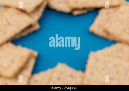 Matzah è disposta ad arte a forma di stella su un vivace tavolo blu, evidenziando un simbolo tradizionale della Pasqua ebraica. Questa configurazione riflette Foto Stock