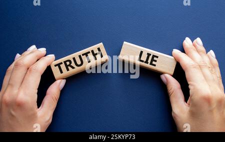 Simbolo della verità o della menzogna. Parola concettuale verità o menzogna su blocchi di legno. Mano d'affari. Splendido sfondo blu intenso. Business and Truth or Lie Concept. Foto Stock
