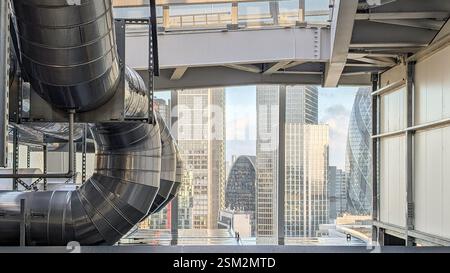 29 gennaio 2025 Londra, Regno Unito - Un contrasto sorprendente tra infrastrutture industriali e uno skyline moderno della città. Grandi condotti d'aria metallici. Foto Stock
