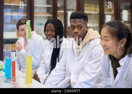 Studenti che osservano la reazione chimica nel laboratorio universitario Foto Stock