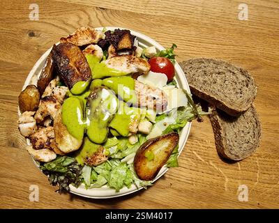 Gustate una sana insalata di pollo alla griglia condita con crema di avocado per la massima freschezza Foto Stock