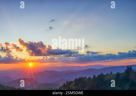 Una vibrante alba sulle Great Smoky Mountains, che getta luce dorata su colline ondulate e nuvole, creando un paesaggio mozzafiato e sereno. Foto Stock