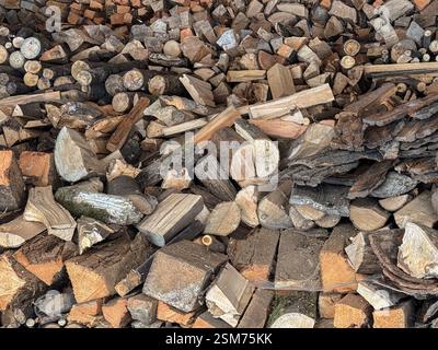 Una vista dettagliata dei tronchi di legna da ardere tritati disposti in pile assortite e impilate, che presentino le consistenze naturali e le preparazioni per la combustione o il magazzinaggio, Foto Stock
