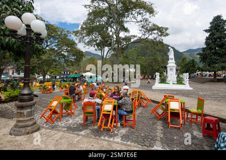 Persone che si rilassano su una pagina colorata nella piazza principale, Jardin, Antioquia, Colombia Foto Stock