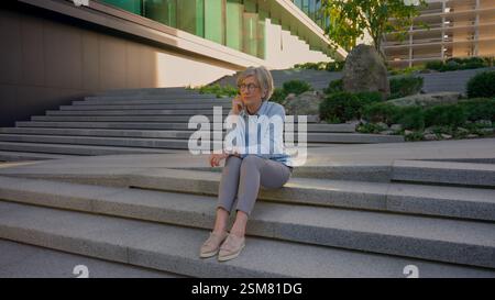 Turbato pensivo triste preoccupata vecchia donna d'affari caucasica senior pensando pensieri di dolore signora matura contemplare all'aperto preoccupare il fallimento della carriera Foto Stock