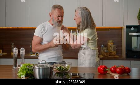 Malato malato vecchio malvagio pensionato cattivo sensazione attacco di cuore bruciore di stomaco nel torace problemi di salute in cucina stressato donna matura moglie aiuto Foto Stock