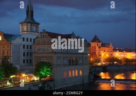 Il Ponte Carlo, simbolo della storia e della bellezza di Praga, si estende lungo il fiume Moldava. Il ponte è illuminato di notte, emettendo un bagliore magico Foto Stock