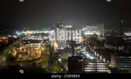 Il centro di Stevenage di notte mostra edifici illuminati, parcheggi, strade e uno stadio di calcio Foto Stock