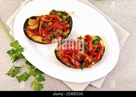 Bruschetta con arrosti di pomodori e peperoni, aglio, cipolle e prezzemolo in una ciotola su un tovagliolo contro lo sfondo di un tavolo di granito alto Foto Stock