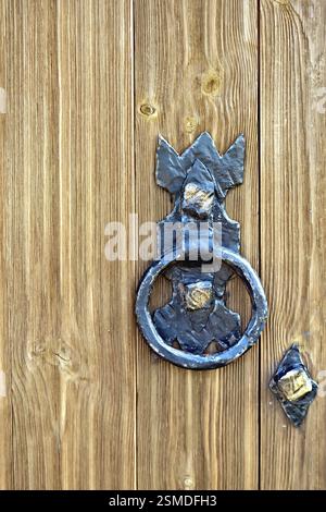 Vecchia porta di legno con letti in ferro battuto con maniglia Foto Stock