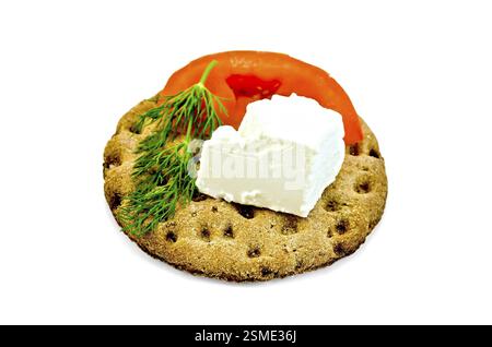 Un pezzo di formaggio feta, una fetta di pomodoro, aneto su un round di pani croccanti di segale isolati su sfondo bianco Foto Stock