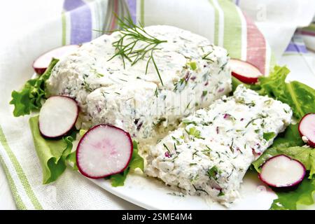 Terrina di ricotta e radicchio con aneto, erba cipollina, insalata in piastra bianca, un tovagliolo in una luce tavole di legno Foto Stock