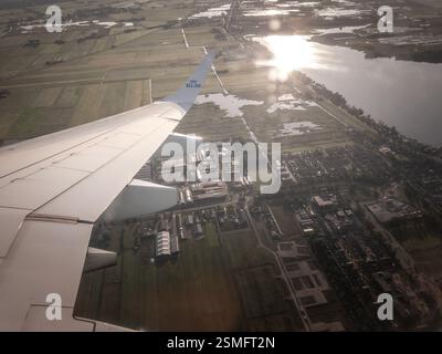 SCHIPOL, PAESI BASSI - 12 AGOSTO 2024: Un aereo olandese della KLM che vola sopra i Paesi Bassi, rivelando campi patchwork, vie navigabili, e. Foto Stock