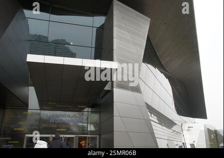 Un cartello multilingue in tedesco, inglese, spagnolo, cinese e coreano dà il benvenuto ai visitatori dello stabilimento BMW di Monaco, Germania. E' il quartier generale. Foto Stock