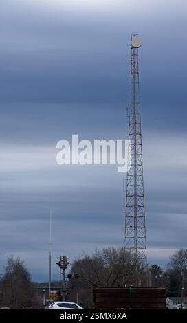 Radio tower con tamburo per microonde contro un cielo blu nuvoloso Foto Stock