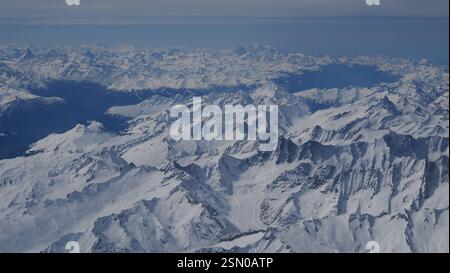 Vista aerea delle vette innevate che si estendono attraverso il paesaggio Foto Stock