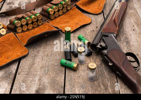 Fucile e munizioni disposti su una superficie di legno pronti per la caccia o la pratica di tiro in un ambiente all'aperto Foto Stock