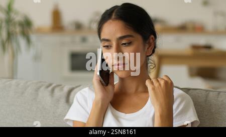 Emotivo negativo cattiva conversazione distante litigio donna indiana parlare telefonare smartphone a casa infastidito irritato ragazza araba parlare femminile Foto Stock