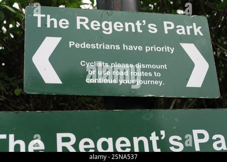 Cartello all'ingresso del Regent's Park di Londra, che dice ai ciclisti di scendere e dare la priorità ai pedoni Foto Stock