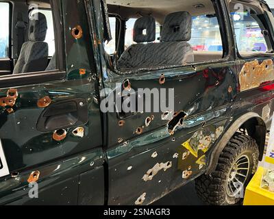 Leopoli, Ucraina - 12 febbraio 2025: Veicolo militare danneggiato che mostra buchi di proiettile e ruggine che mette in evidenza atti vandalici e resilienza Foto Stock