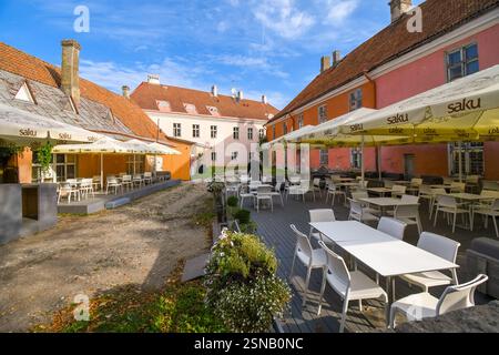 Un lavoratore di servizio predispone un cafe' all'aperto per i clienti nella zona medioevale della collina di Toompea, parte della Città Vecchia di Tallinn, Estonia. Foto Stock