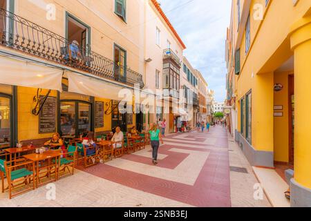 Una strada o un vicolo pittoresco di negozi e caffetterie nella storica città vecchia di Mahon Minorca, Spagna, sull'isola mediterranea delle Baleari di Minorca. Foto Stock