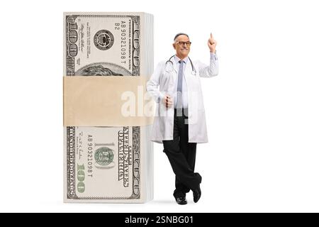 Medico maschio maturo con un sacco di soldi che puntano isolato su sfondo bianco Foto Stock