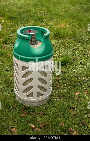 Bottiglia di gas verde di composito in piedi da sola su un prato, Danimarca, 13 febbraio 2025 Foto Stock