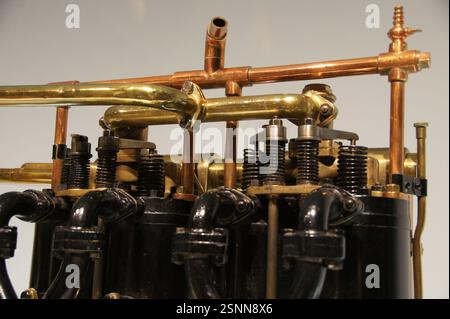 Un primo piano di un motore d'auto d'epoca in Germania, Monaco rivela parti in ottone lucido che brillano contro il monoblocco nero. Questo classico motore de Foto Stock