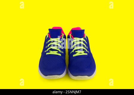 Un paio di scarpe da running colorate, sneaker e sneaker su sfondo giallo brillante con spazio per copiare Foto Stock
