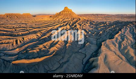 Vista panoramica aerea della Factory Butte all'alba, caratterizzata dalla splendida formazione geologica che si erge quasi come una cattedrale dalla landsca erosa Foto Stock
