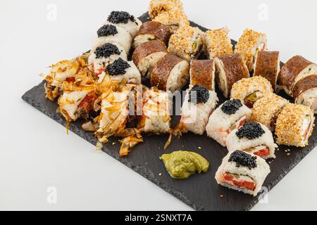 Un piatto di sushi splendidamente organizzato presenta una varietà di panini, evidenziando ingredienti e condimenti colorati, ideale per un'esperienza gastronomica mondana Foto Stock