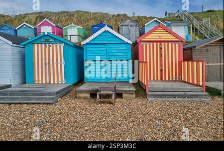 Tradizionali capanne da spiaggia dipinte in legno colorato sulla spiaggia di ciottoli di Milford on Sea, Hampshire Engalnd, Regno Unito Foto Stock