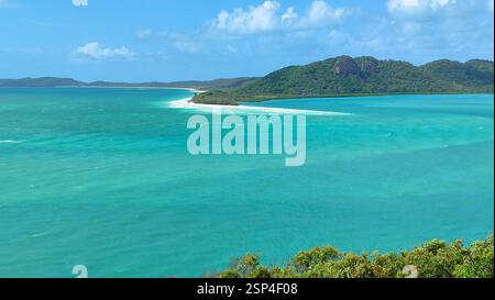 Oceano turchese con una piccola isola di sabbia bianca al centro dell'isola di Hamilton. Questa scena idilliaca incarna un paradiso tropicale e una vacanza da sogno Foto Stock
