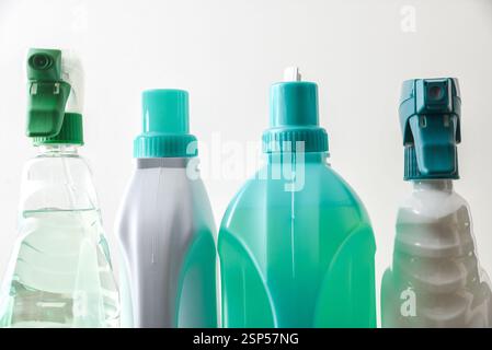 Dettaglio della parte superiore di quattro contenitori in plastica di diversi tipi con prodotti per la pulizia di vari tipi di superfici nei toni bianco e verde e bianco Foto Stock