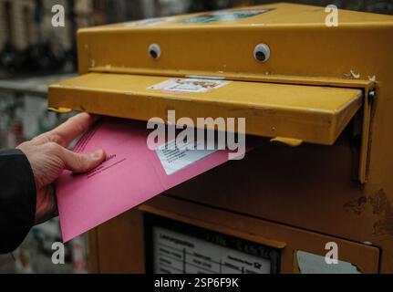 Colonia, Germania. 14 febbraio 2025. Una busta per il voto postale viene gettata in una casella postale. Le elezioni del Bundestag sono il 23.02.2025. Secondo il funzionario federale per il rimpatrio, gli uffici elettorali invieranno i documenti di voto per posta entro il 10 febbraio. Le lettere di voto devono pervenire all'ufficio competente al più tardi entro il giorno delle elezioni, altrimenti le votazioni non saranno prese in considerazione. Crediti: Oliver Berg/dpa/Alamy Live News Foto Stock