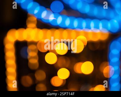 Immagine astratta di luci bokeh colorate in tonalità arancione e blu, che creano un'atmosfera vivace e festosa. Foto Stock