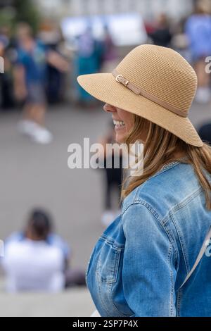 vista laterale di una donna sorridente con cappello Foto Stock