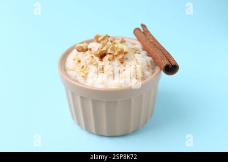 Gustoso budino di riso con noci e cannella su sfondo azzurro, primo piano Foto Stock